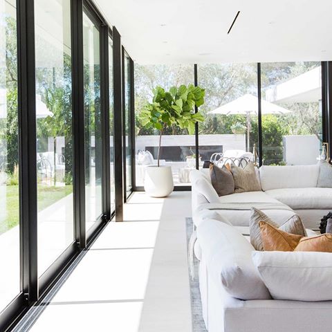 This Saturday morning lounging on a cozy sectional lined with floor to ceiling windows may be as close as we get to enjoying the great outdoors this weekend... + that is perfectly fine with us! Slide those doors open, it’s rest day 🌿💭☀️ // #projectbelair 📷 @tessaneustadt 
Build: @corrcontemporaryhomes 
Architecture: @wolfdesignstudio