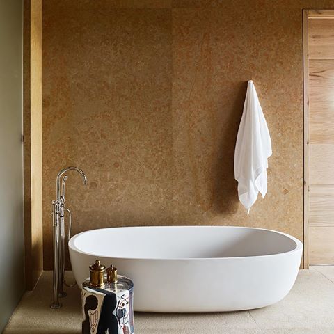 Alpine glamour meets the American West at the luxe @calderahouse in Jackson Hole, Wyoming from Los Angeles firm @CommuneDesign and local firm Carney Logan Burke Architects. In a guestroom, a white soaking tub contrasts white oak-paneled walls for a rustic and inviting feel.  Looking for more bath designs? Go to hospitalitydesign.com for classic styles that have been reinterpreted through a modern lens. #hospitalitydesign #hdmag