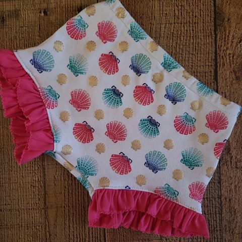 Handmade Shell Ruffle Shorties. Releasing Wednesday, May 8th @7pm est. In our Facebook group, Bogolia Handmade VIP.  Sizes 12n-4T. *option of pink or navy Ruffles. 
Also available in Shorts or matching 18" doll Ruffle outfits. 
Matching Under the Sea Bracelets available now.
#handmade #brandreplife #shorties #trendytoddlers #babieswithstyle #shells #underthesea #summer #spring #colorful #childhoodunpluged #childhood #dreams #replife #littlegirls #love #fashionista #fashion #toddlersofinstagram #fashionista #shopsmallshops #supportsmallbusiness #beach