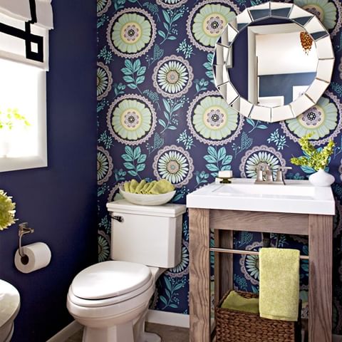 In this half bath, one wall of patterned wallpaper is all it takes to make a bold statement! Bright green mixes with turquoise and a deep blue to form a one-of-a-kind color palette. A rustic wood vanity adds character to the space while white accessories brighten the room. 🙌 Tap the link in our bio to see more color combinations that surprisingly work well together. #bhghome 📷: @johneeebee | Designer and homeowner: @Jenna_Burger