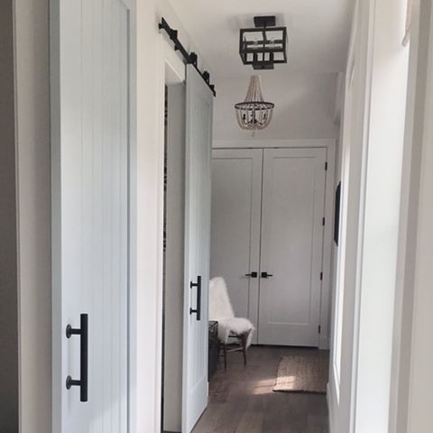 The vision is complete in our hallway!! Our house plan was designed around this hallway that is in the front of the house:) It was a must have on my list after seeing a home that Chip and Joanne did on Fixer Upper @joannagaines  The features are the barn doors that I decided to paint and the big windows across from them! I’m in love💕😊 and I do the happy dance while I go down the hall 💃. Tip for barn doors...backing, backing, backing!! #farmhousefollowfriday
#fabulousfarmhousefriday
#mystyleoffarmhouse 
#builderofig
#brightwhitesofig
#mybghhome
#modernfarmhouse
#modernfarmstyle #modernfarmdecor
#farmhouse
#husbandandwifeteam
#housebeautifulhome #myhousebeautiful #houseandhome #betterhomesandgardens #inspire_me_home_decor #myspaceanddecor #mycountryhome #fixerupper #fixerupperstyle #hallway #barndoors #customhomes