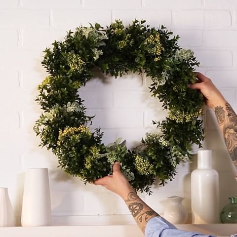 This DIY wreath is perfect for beginners and it only takes about 45 minutes to make! Faux boxwood and artificial sprigs of greenery are key to its long-lasting beauty 🌿 Tap the link in our bio for the full instructions, and display it season after season! #bhghome